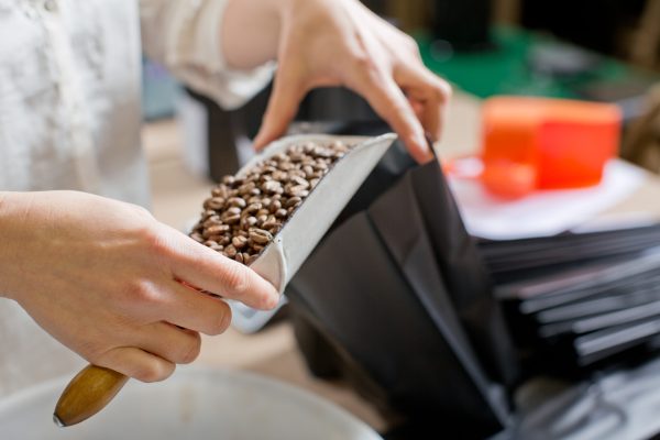 Coffee seller filling bag with coffee beans